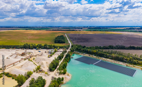 Принти на полотні Solar panels sit on water near a construction site in a rural area
