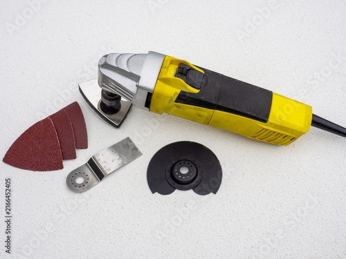 Obraz na plátne Oscillating multi-tool power tool with yellow and black body, shown on a white t