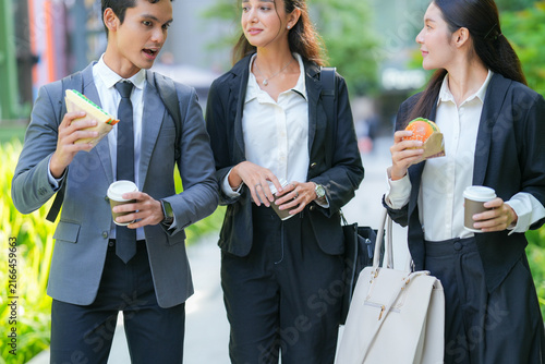 Photography A group of three smartly dressed coworkers taking a lunch break away from the of