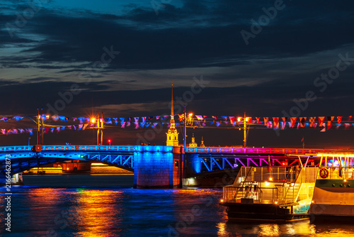 Fotografie The Peter and Paul Cathedral and Palace Bridge in the colors of the Russian flag at night