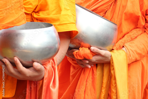 Fotografie Close-up of Buddhist monks holding alms bowls in traditional orange robes