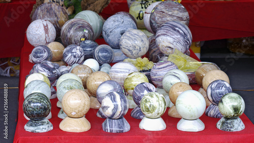 Fotografía Vibrant polished gemstone spheres and crystal balls arranged on a red table representing feng shui and balance