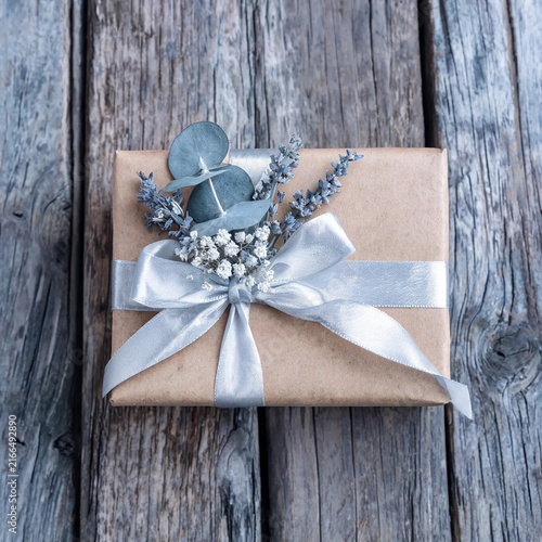 Kraft Gift Wrapped Box With Dried Flowers On Rustic Wooden Boards