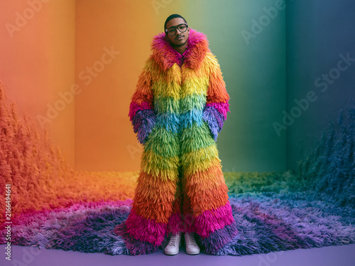 Stylish Man Wearing Colorful Rainbow Fur Coat in Studio