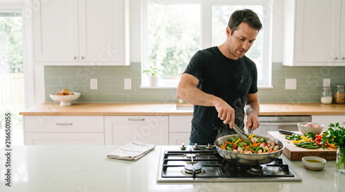 Man preparing a healthy meal with fresh vegetables in the kitchen