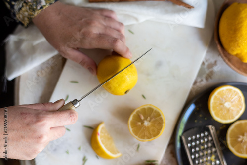 Bild auf Leinwand Hands slicing fresh lemons precisely
