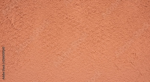 Uniform terracotta orange plaster wall texture provides rustic surface for architectural design and construction material backdrop.