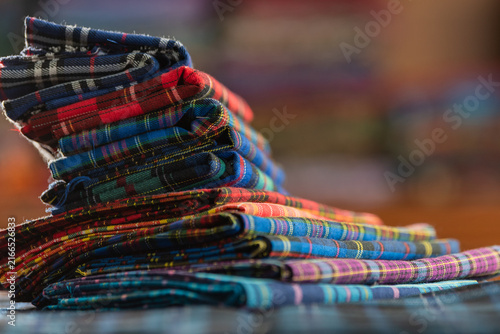 Fotografie Colorful textile stack of vibrant fabric with detailed weave and pattern checkered samples in warehouse