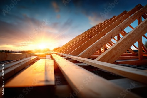 Wooden roof truss construction at sunrise, symbolizing new beginnings and home building