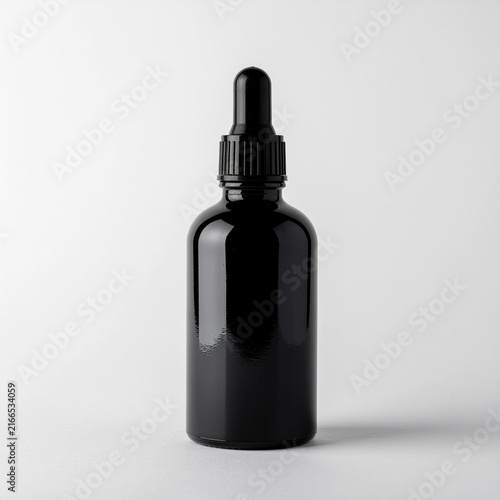 Dark glass dropper bottle on a light background mockup