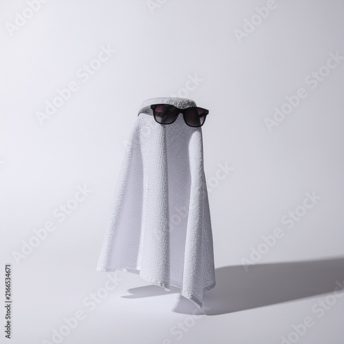 Minimalist humor concept of white towel ghost with glasses