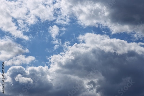 Fotografie Dark storm clouds clearing to blue sky background with copy space