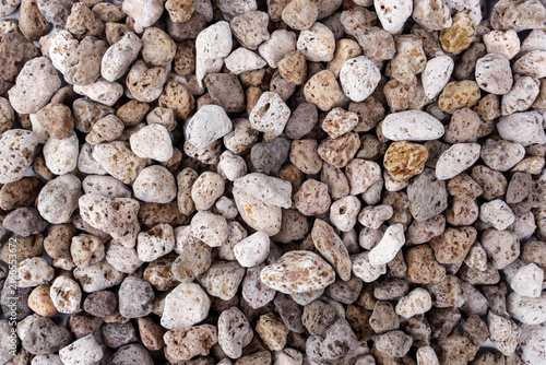 Background Pile of volcanic pumice rock stones is wet from cleaning isolated on white background. lightweight porous lava rocks for plant soil drainage gardening and aquarium filtration.