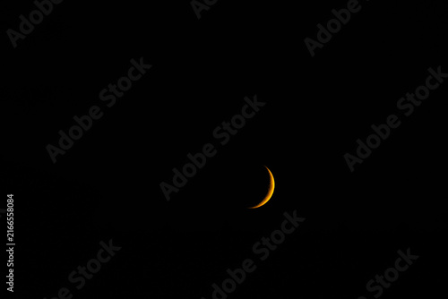 Foto A delicate golden sliver of a crescent moon glowing brightly against the pitch-black canvas of the deep night sky