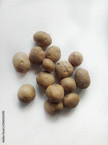 Fresh raw potatoes arranged on a clean white background, showcasing natural organic vegetables, healthy food ingredients, and rustic farm produce.k