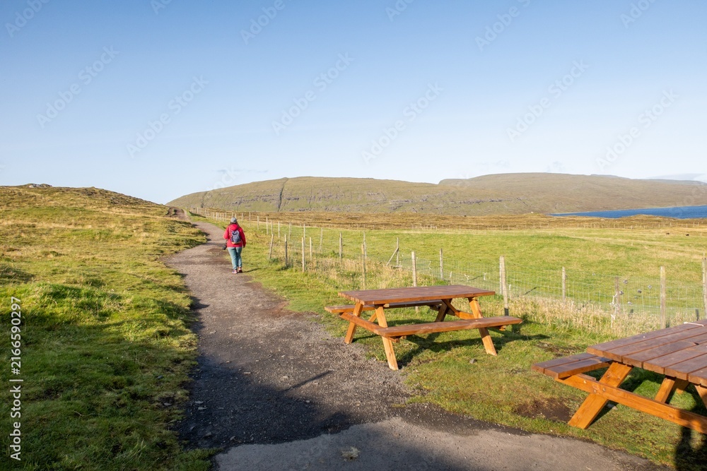 Fototapeta premium Woman hiking path in Faroe Islands landscape