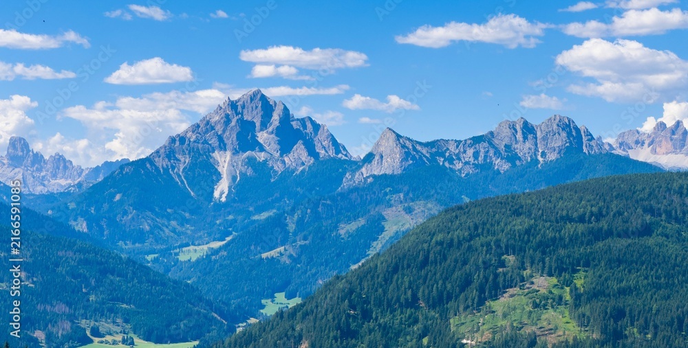 Naklejka premium Majestic scenery of rough mountain ridge near grassy hills 
