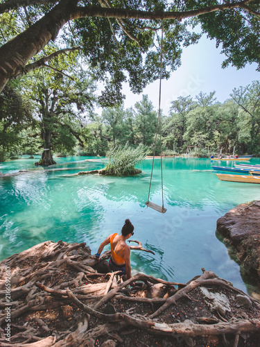 Lone traveler explores turquoise waters beneath tangled roots