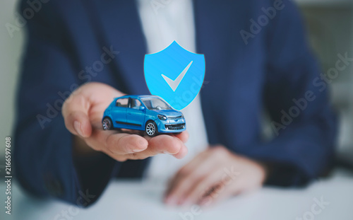 Obraz na płótnie Car insurance protection with businessperson holding model car to represent vehicle coverage financial security risk management accident protection trust and reliable automotive insurance