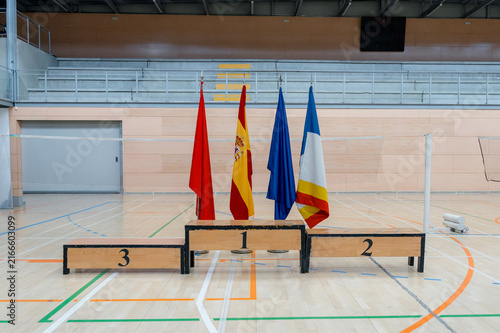 Badminton tournament podium with flags in indoor sports hall
