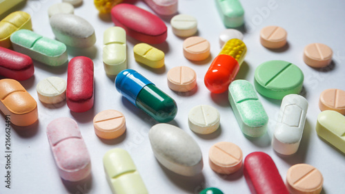 Fotografie Colorful antibiotics and some health supplements are scattered on white surface