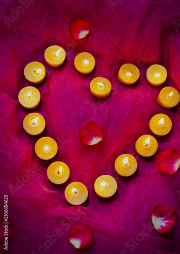 Romantic heart shaped candles glowing in the pink