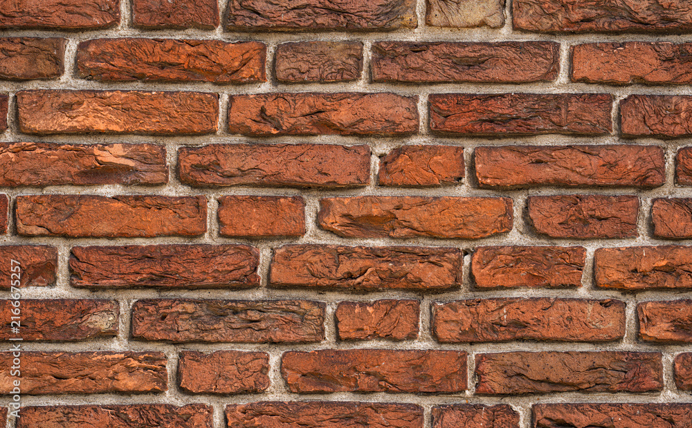 Fototapeta premium Brick wall with aged reclaimed material. Brick pattern on a rustic exterior. Antique weathered brick in close detail. Architectural texture of brick and mortar.