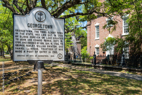 The historic town marker for Georgetown, South Carolina, designated as the third-oldest town in the state, with the Prince George Winyah Parish Church behind in view behind.