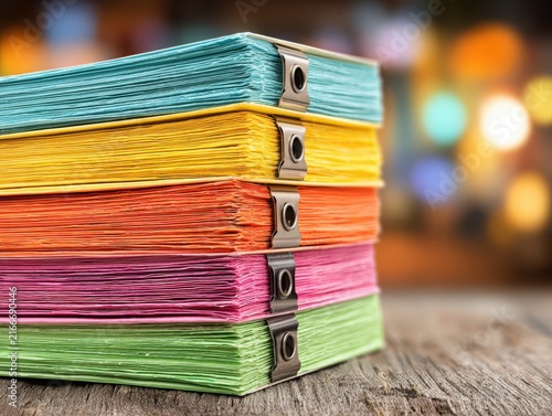 Colorful paper stacks secured with clips on a wooden table  