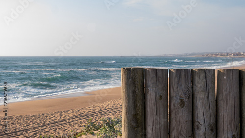 Weathered Timber Boardwalk Railing Overlooking a Wide Empty Sandy Beach and Breaking Atlantic Waves, Portugal — Coastal Walk, Sea View and Calm Escape Concept