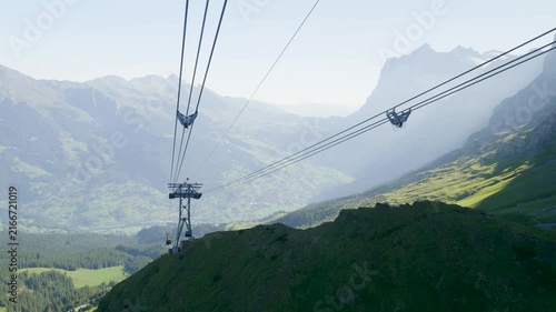 Point of view from a cable car going down a mountain over a beautiful green valley in switzerland. Switzerland