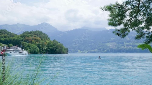 Scenic view of a person on a paddleboard on the turquoise lake brienz in switzerland. Switzerland