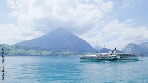 Paddle steamer navigating the turquoise waters of lake thun with the niesen mountain in the background. Switzerland