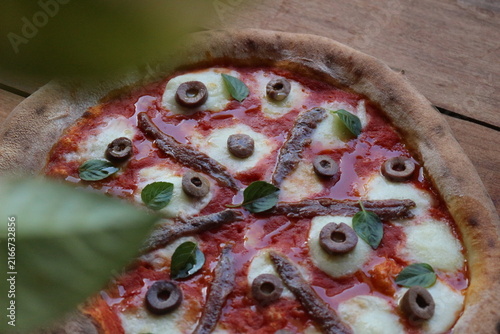 Cuadro en lienzo Pizza artesanal vista parcialmente de cima, coberta com molho de tomate, queijo derretido, azeitonas verdes e pretas fatiadas e folhas de manjericão