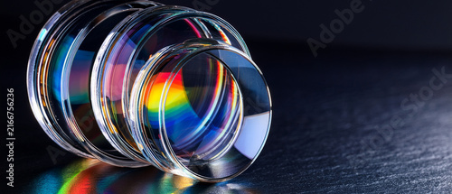 Optical glass lenses with rainbow light spectrum dispersion on dark background