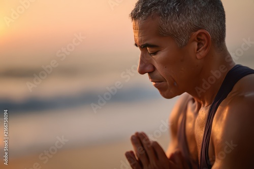 Meditating man closeup in prayer pose on beach poster for international day of yoga mindfulness and wellness background at sunrise