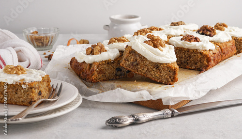 Homemade carrot cake bars with cream cheese frosting and walnuts, delicious sweet dessert slices for celebration or autumn holiday