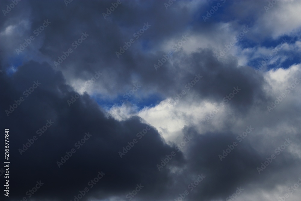 Fototapeta premium Dark storm clouds with patches of blue sky