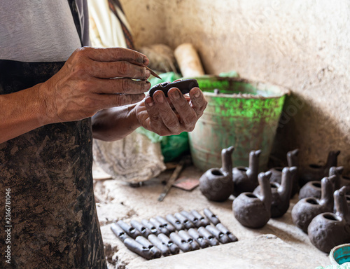 Quadro su tela Artisan crafting traditional clay bird whistle in pottery studio
