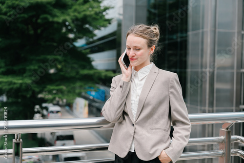 The businesswoman conducting business transactions negotiations while feeling calm and focused outdoors near office building