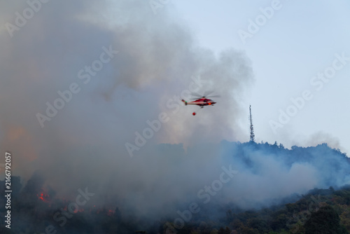 Wildfire on Hillside with Firefighting Helicopter near Residential Area