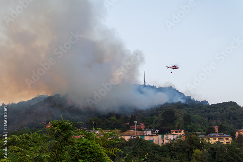 Wildfire on Hillside with Firefighting Helicopter near Residential Area