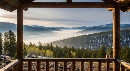 Scenic mountain view from a rustic wooden cabin porch at sunrise with valley fog