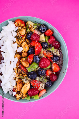 Colorful smoothie bowl with fruits, granola, and coconut flakes