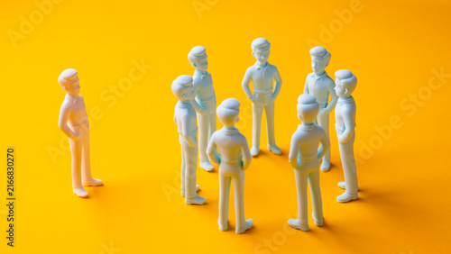 Foto Workplace exclusion and social isolation with one person separated from group