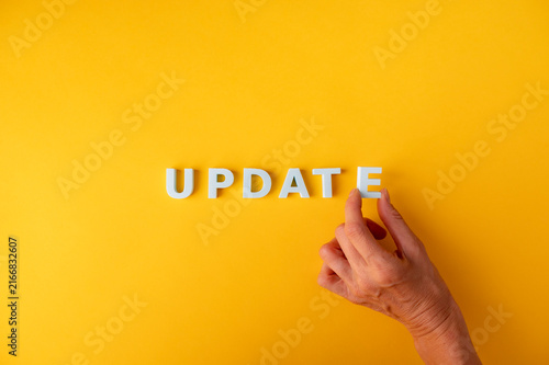 Update and upgrade concept with hand arranging UPDATE letters