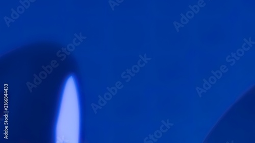 Abstract blue liquid splash with dynamic motion and glossy metallic reflections in dark studio