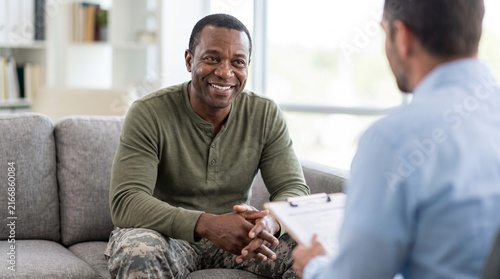 Smiling African American Soldier Talking With Counselor At Clinic