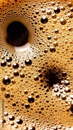 Macro view of golden coffee bubbles and espresso foam.