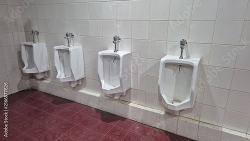 Fotografía Clean public restroom with multiple wall-mounted ceramic urinals aligned in a tiled bathroom interior